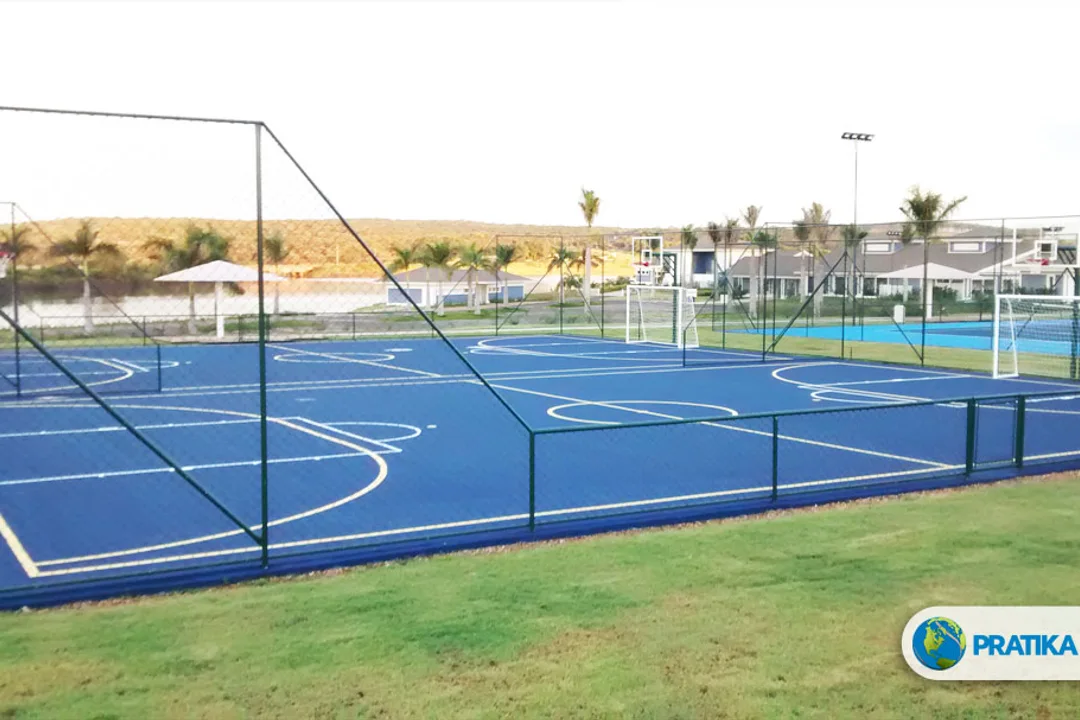 Foto do acervo da Pratika Sport: quadra multiuso azul com traves, cestas e alambrado