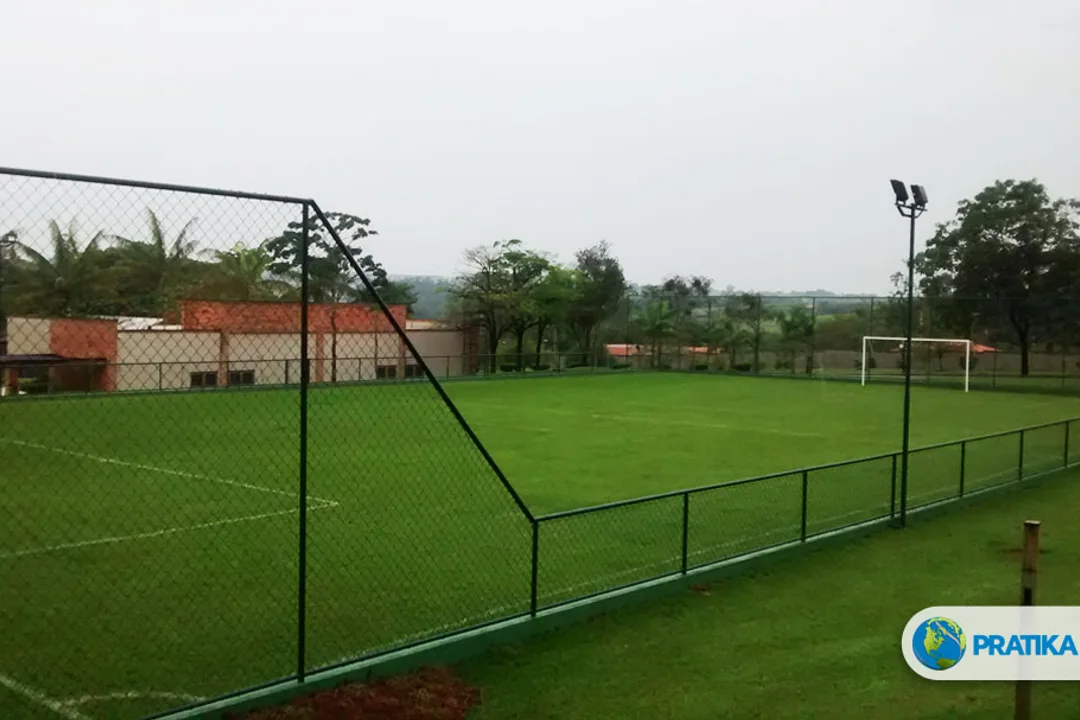 Foto do acervo da Pratika Sport: campo de futebol com gramado, traves e cercamento